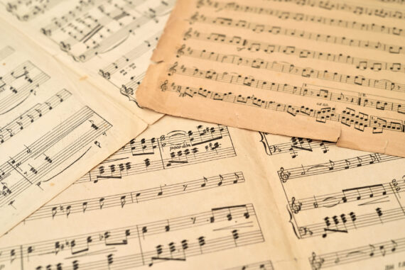 Old sheets with music notes scattered on the table. Close-up. Retro style. Selective focus.